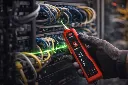 Technician tracing cables in server rack.webp